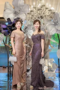 親家母分別穿著古銅金與深紫色珠工媽媽禮服，同調不同色搭配，展現高雅協調的婚禮穿搭效果。